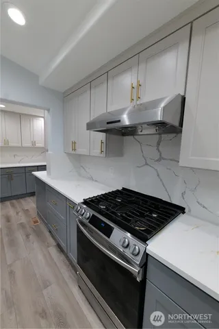 a kitchen with stainless steel appliances a stove a sink dishwasher and cabinets with wooden floor