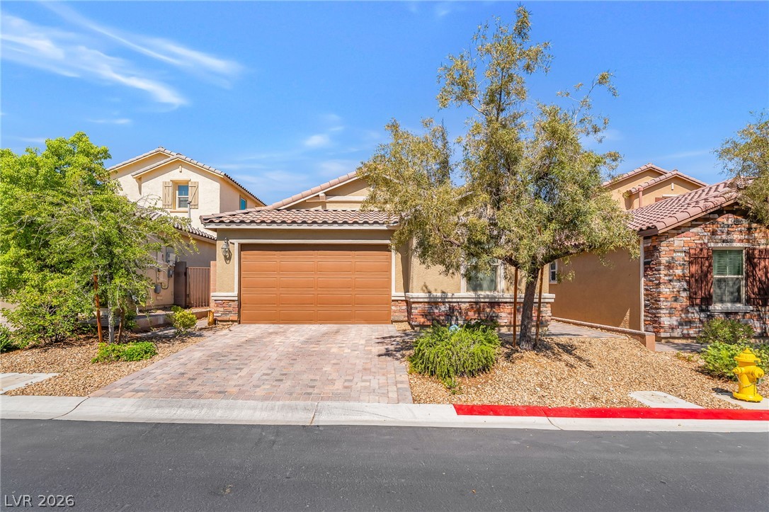 6245 Andover Wood Road Las Vegas, NV 89113 - Photo 2 of 37 A well-kept front yard and brick driveway lead to this charming residence.