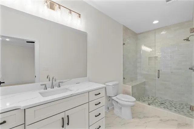 a bathroom with a sink a toilet and shower