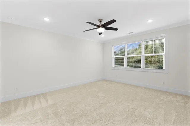 an empty room with window and a ceiling fan