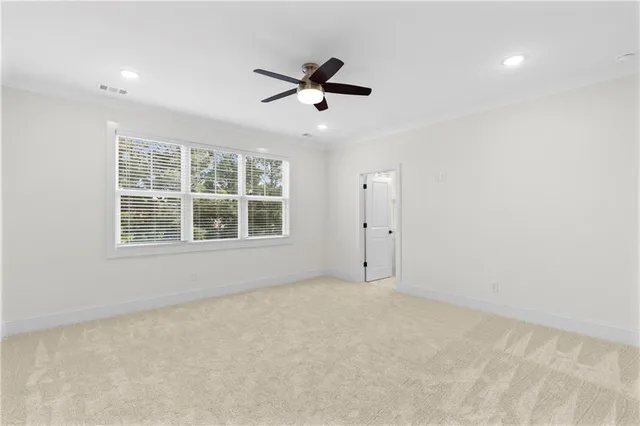 an empty room with a window and ceiling fan