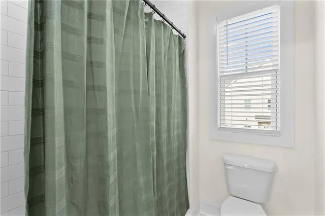a bathroom with a shower curtain and a toilet