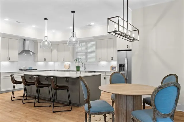 a kitchen with stainless steel appliances granite countertop a sink a stove a refrigerator and island