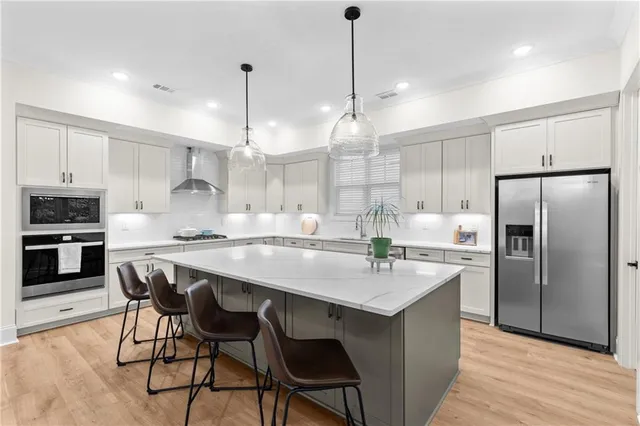 a kitchen with kitchen island a refrigerator a stove a sink and chairs