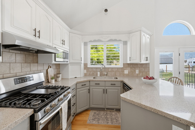 3732 Campbell Road Tooele, UT 84074 - Photo 14 of 69 Vaulted ceiling kitchen featuring white upper cabinetry, gray lower cabinetry, and light-toned countertops