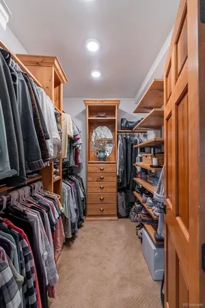 a view of walk in closet with clothes and shoes