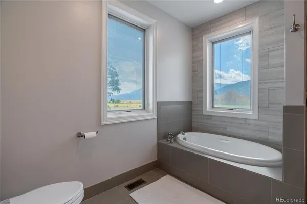 a bathroom with a granite countertop toilet a sink and bathtub