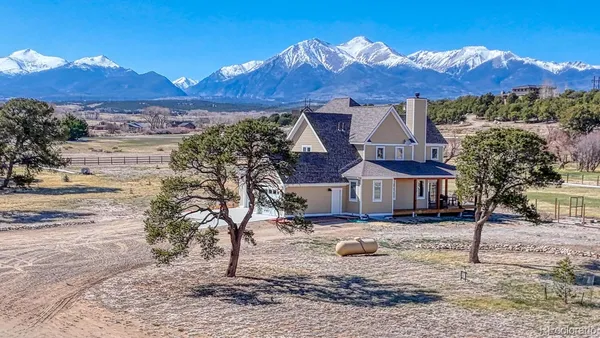 a front view of a house with a yard and mountain view