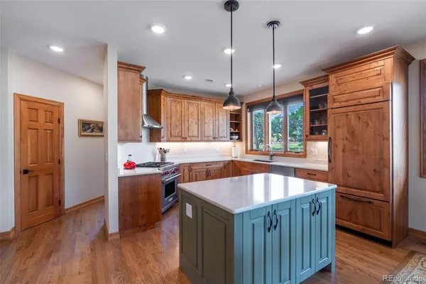 a kitchen with stainless steel appliances granite countertop sink stove and wooden floor