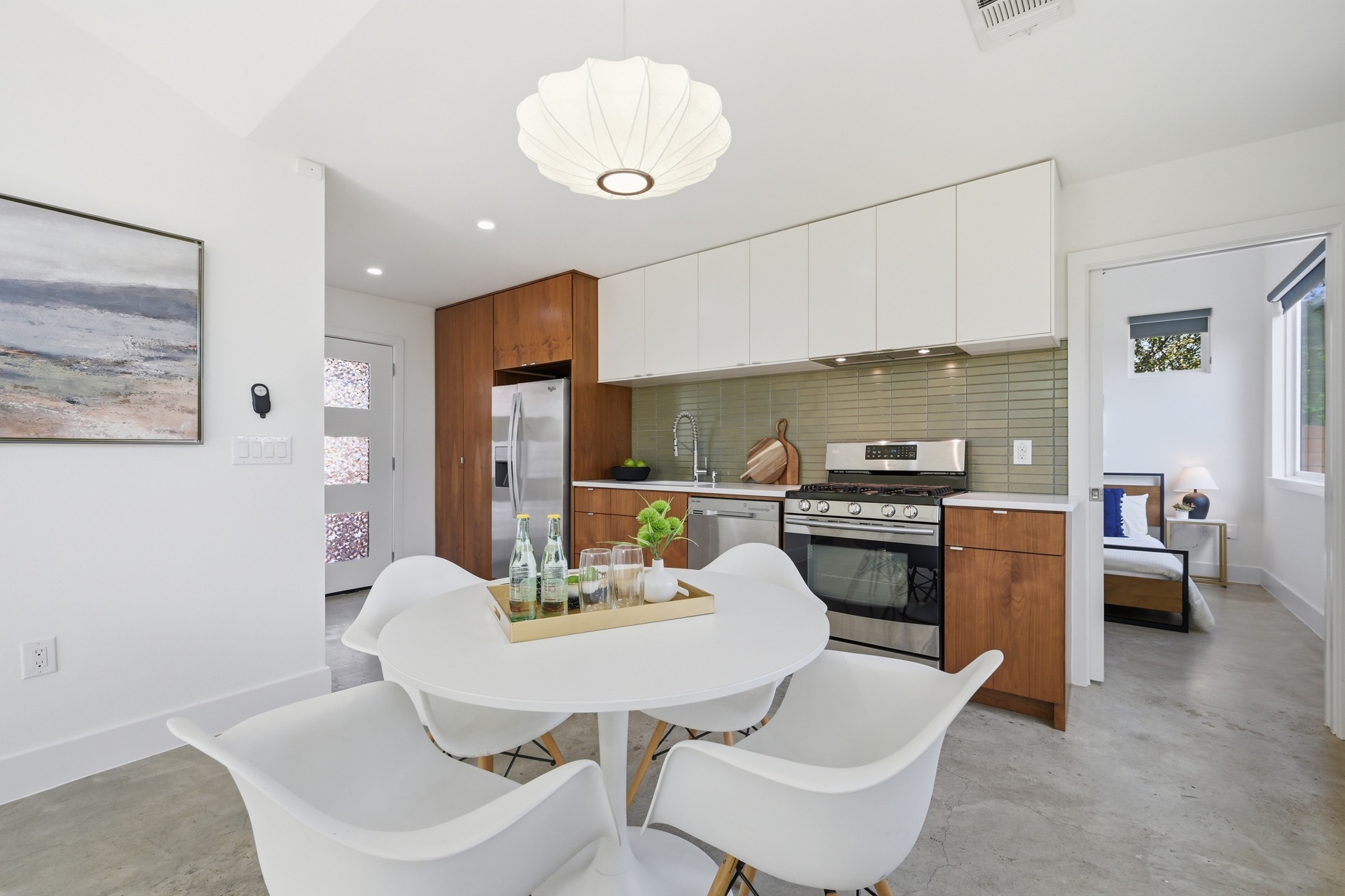 1805 Tillery Street Austin, TX 78721 - Photo 11 of 23 Kitchen with light countertops, dual tone cabinets, finished concrete floors, stainless steel appliances, and modern cabinets