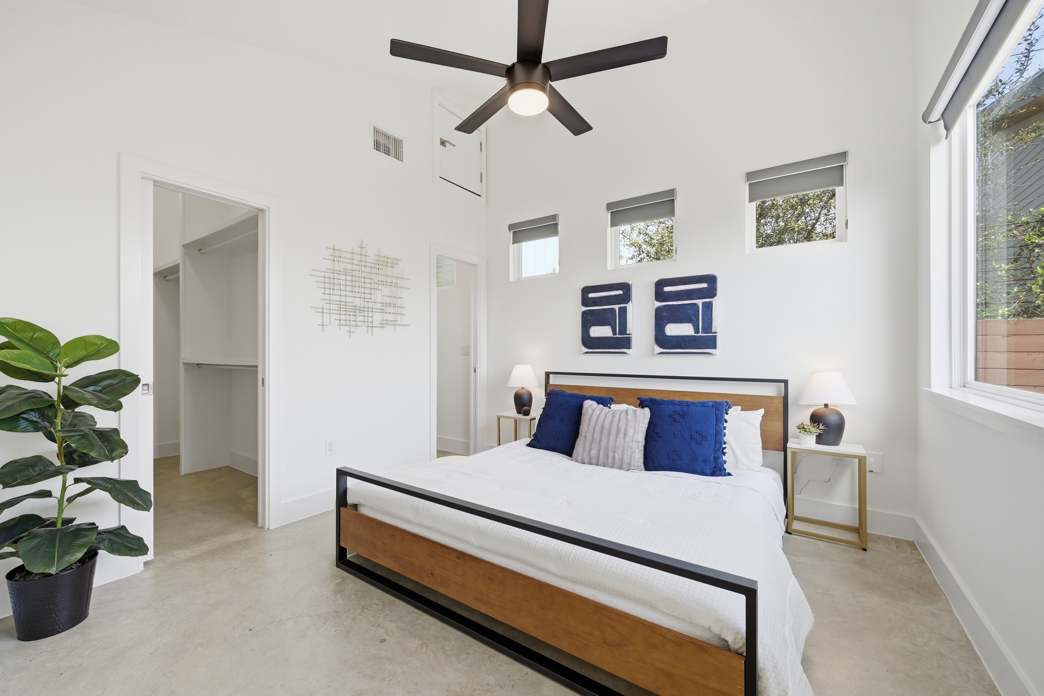 1805 Tillery Street Austin, TX 78721 - Photo 13 of 23 Bedroom with a high ceiling, a walk in closet, finished concrete floors, and ceiling fan