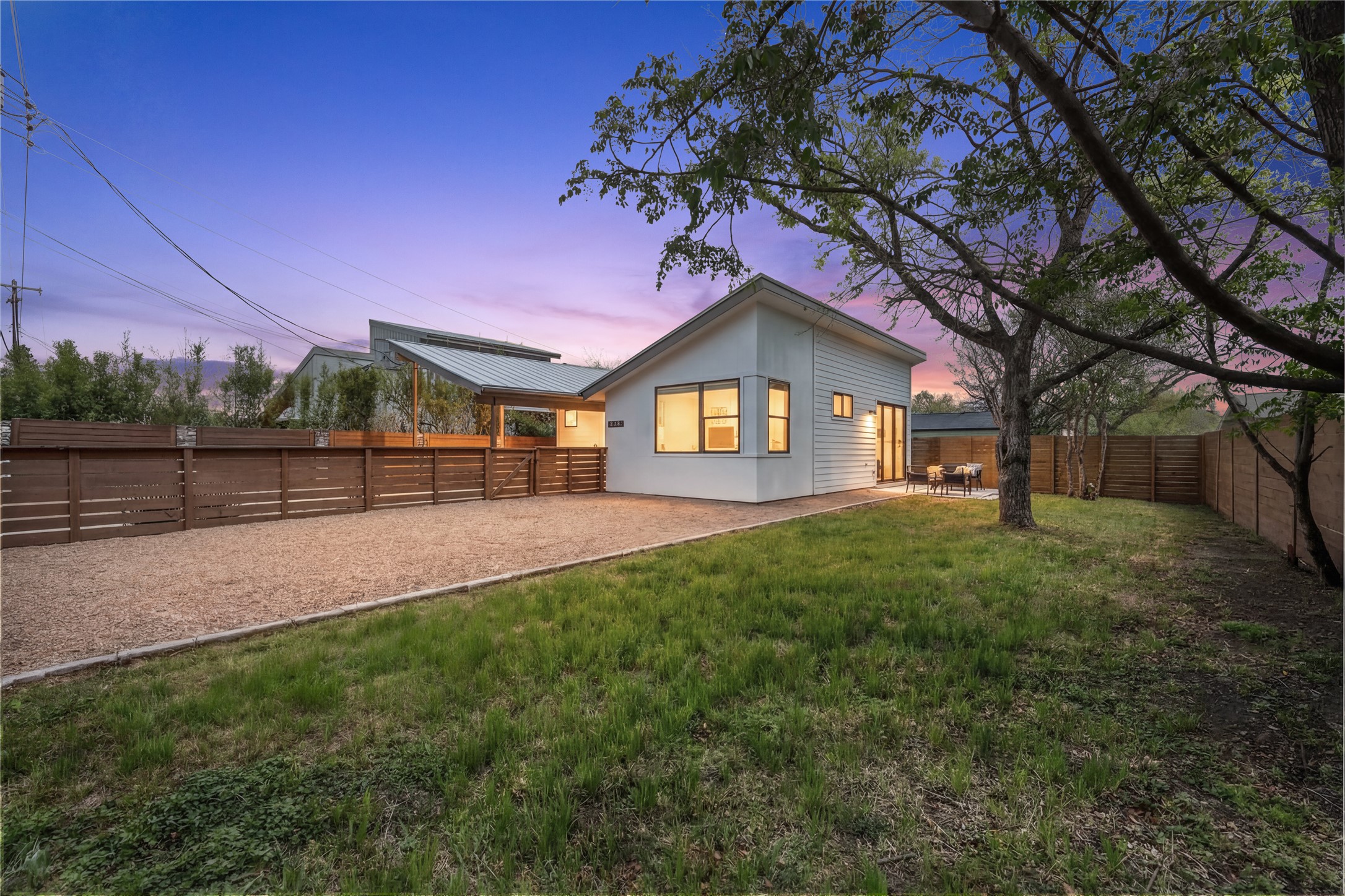 1805 Tillery Street Austin, TX 78721 - Photo 2 of 23 Rear view of property featuring a fenced backyard, stucco siding, and a metal roof