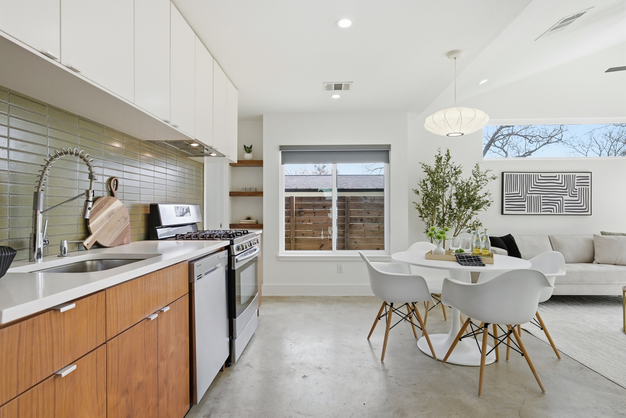 1805 Tillery Street Austin, TX 78721 - Photo 5 of 23 Kitchen featuring concrete flooring, stainless steel appliances, plenty of natural light, and tasteful backsplash