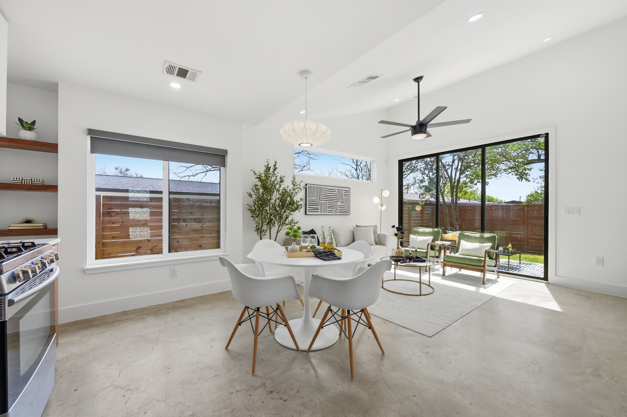 1805 Tillery Street Austin, TX 78721 - Photo 6 of 23 Dining room with finished concrete flooring, a ceiling fan, and a high ceiling