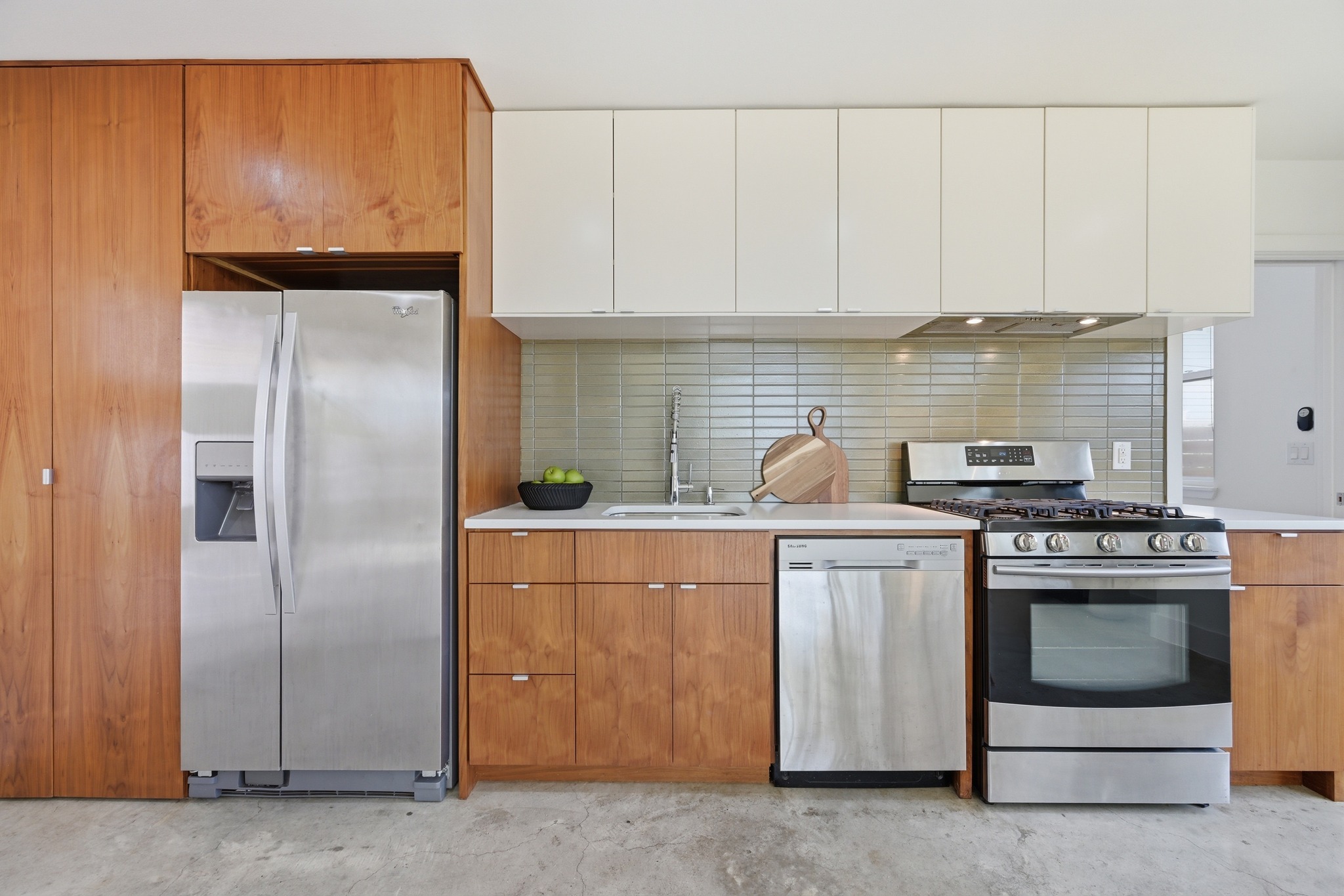 1805 Tillery Street Austin, TX 78721 - Photo 7 of 23 Kitchen with stainless steel appliances, two tone cabinets, modern cabinets, concrete floors, and tasteful backsplash
