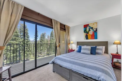 a bedroom with a large bed and a painting on the wall