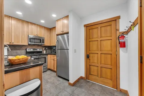 a kitchen with stainless steel appliances granite countertop a refrigerator and a stove top oven