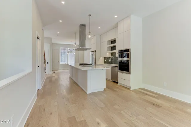 a large white kitchen with white cabinets and stainless steel appliances