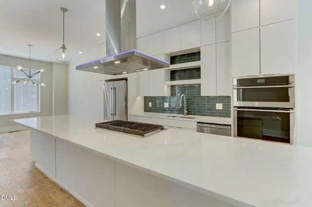a kitchen with stainless steel appliances a sink a stove and a refrigerator