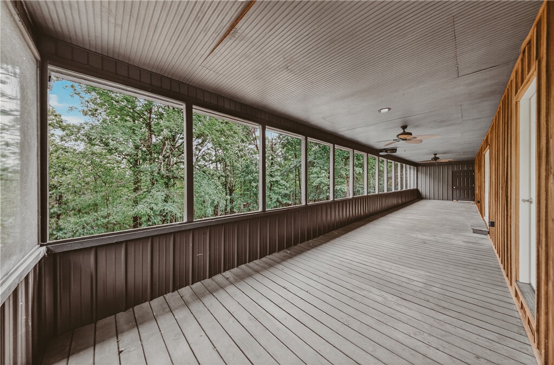 648 Dequeen Lake Road De Queen, AR 71832 - Photo 7 of 46 Expansive screened-in porch with wood flooring, ceiling fans, and views of surrounding nature - get ready to relax!