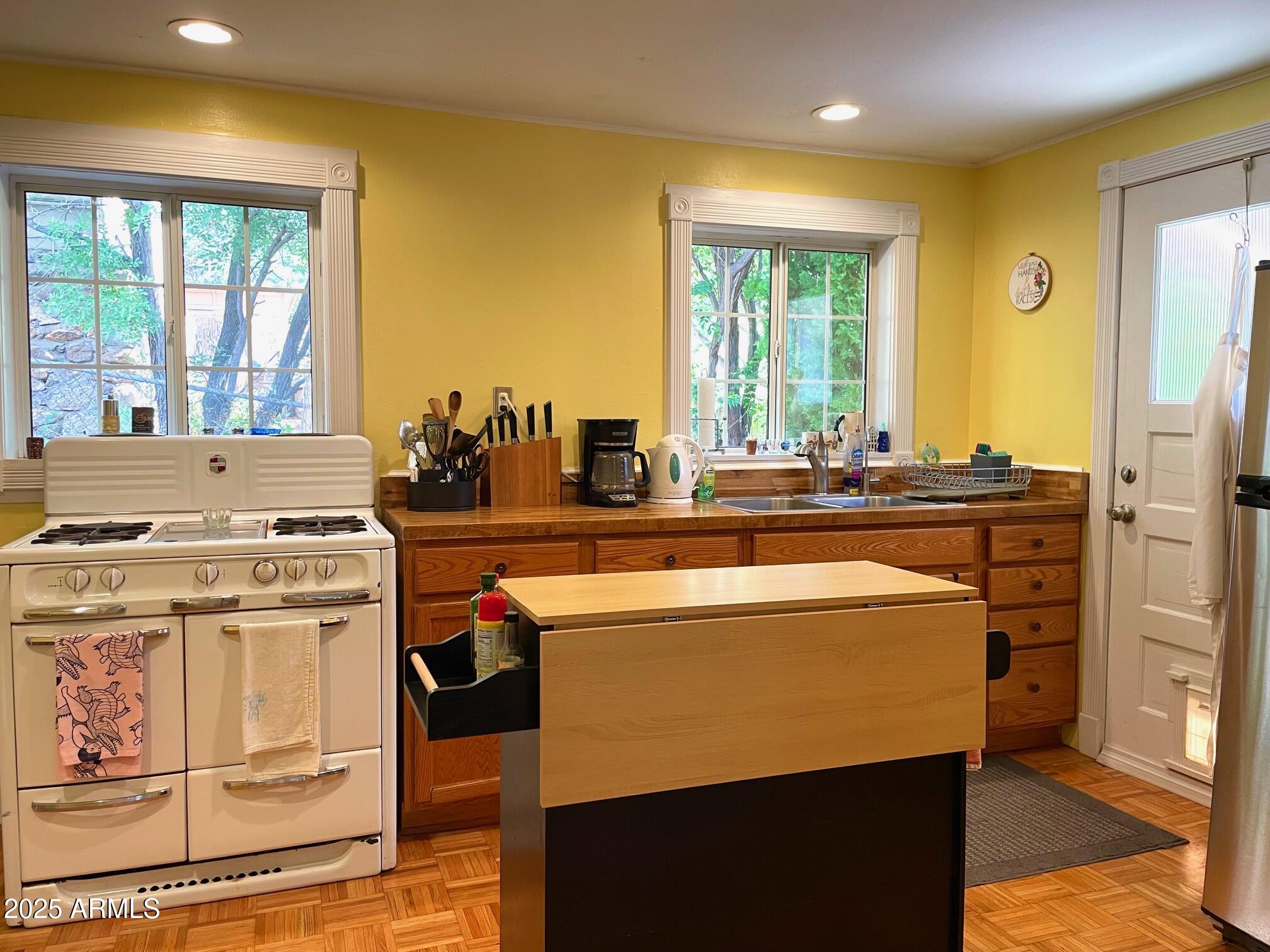 10 Locklin Avenue Bisbee, AZ 85603 - Photo 18 of 35 a kitchen with a stove a sink and a refrigerator