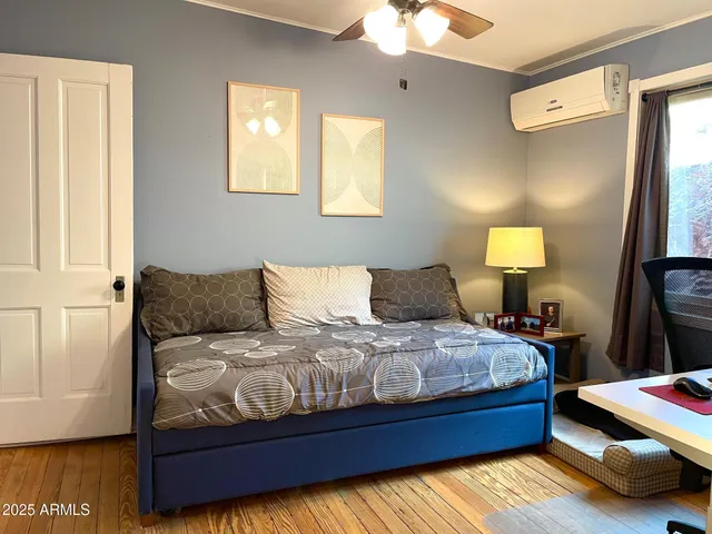 a bedroom with a bed and a lamp on dresser