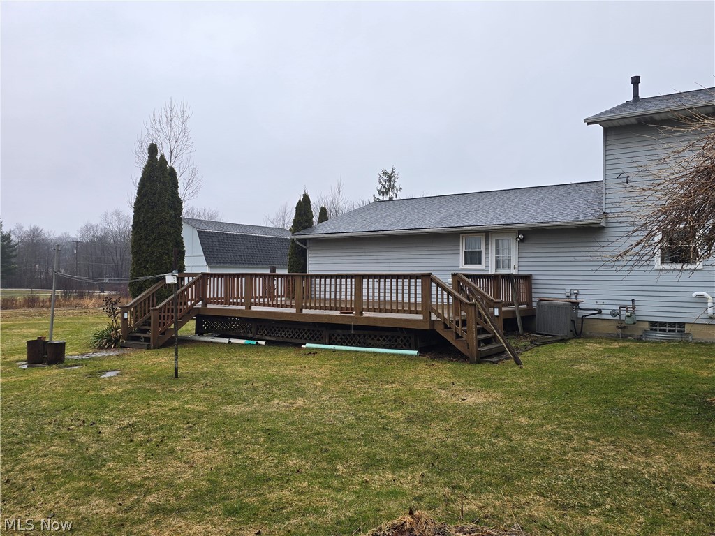 2672 Crackel Road Aurora, OH 44202 - Photo 16 of 38 Back of property featuring a shingled roof, a wooden deck, and a lawn