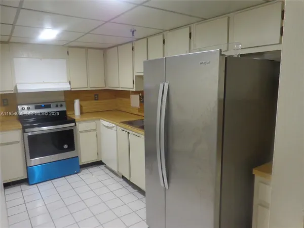a kitchen with a refrigerator sink and cabinets