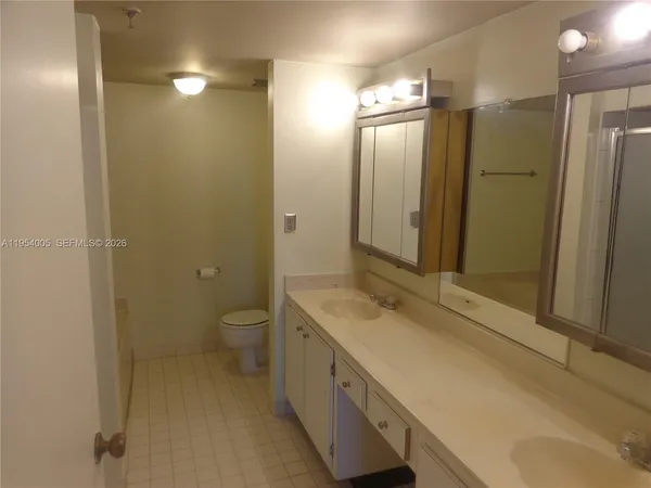 a spacious bathroom with a granite countertop sink toilet and shower