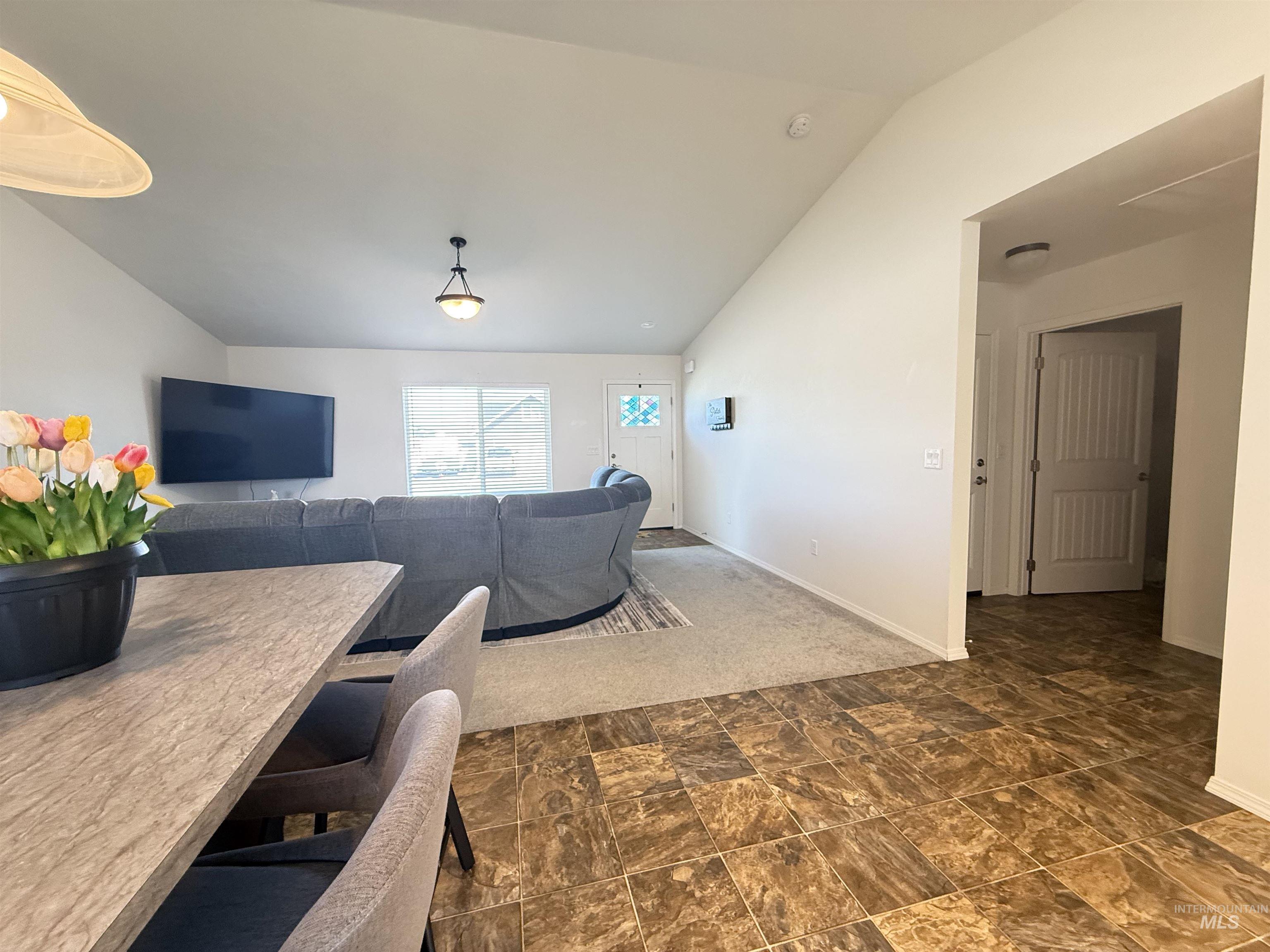 1556 Frontier Drive Lewiston, ID 83501 - Photo 20 of 23 Vaulted ceiling living area featuring a large window, neutral carpeting, and a ceiling-mounted light fixture