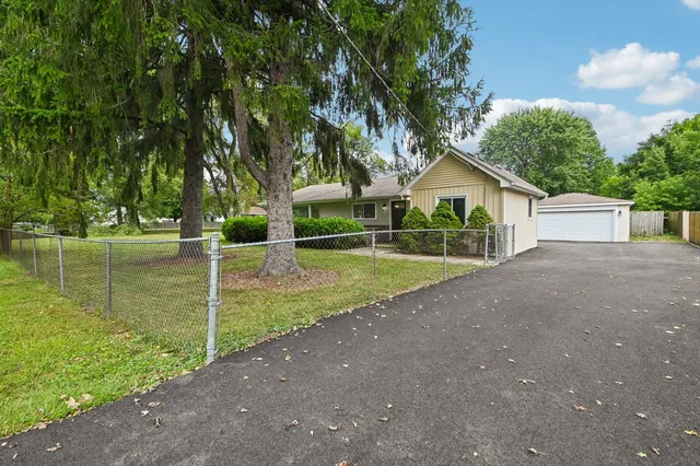 a view of a house with backyard and a tree