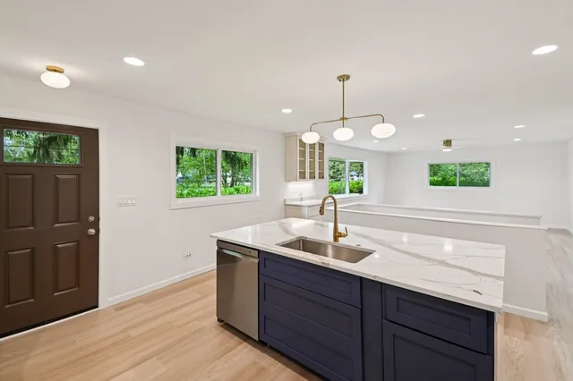 a kitchen with a sink and wooden floor