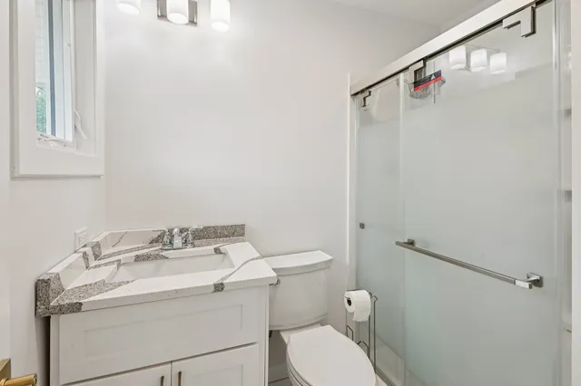 a bathroom with a sink a toilet and shower