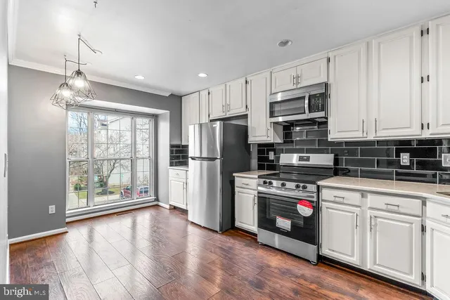 a kitchen with stainless steel appliances granite countertop a refrigerator a stove a sink and a microwave