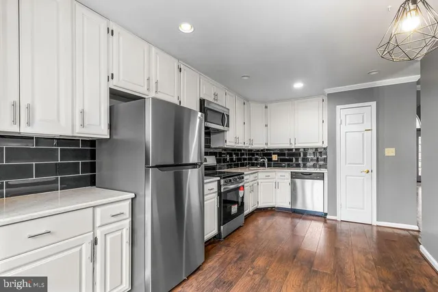 a kitchen with stainless steel appliances a refrigerator sink and cabinets
