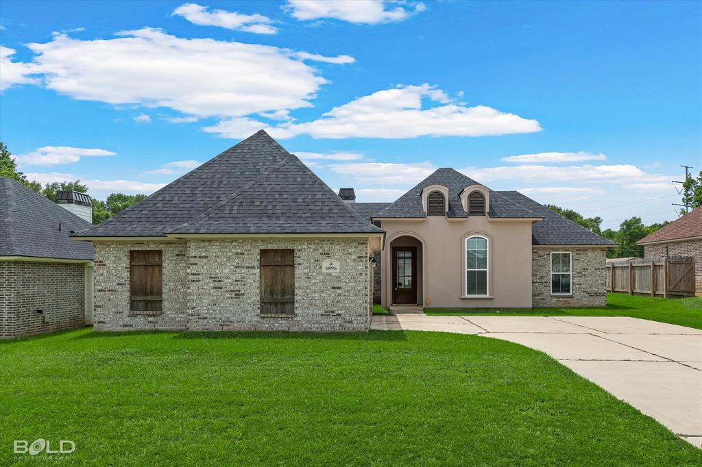 Single-story residence featuring a combination of light-colored brick and stucco exterior