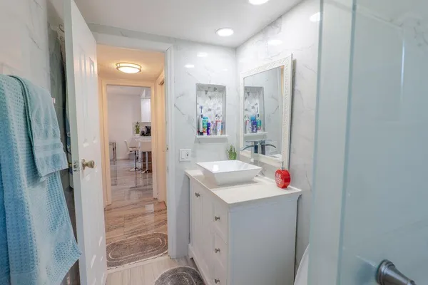 a bathroom with a sink mirror and shower
