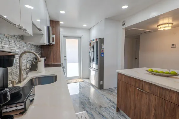 a kitchen with kitchen island a sink stove and refrigerator