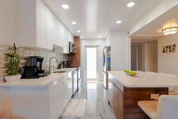 a kitchen with sink refrigerator and cabinets