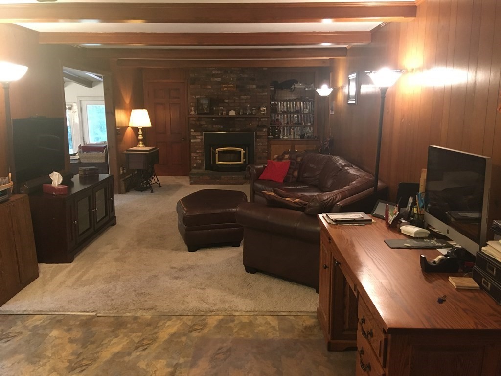 18 Butternut Drive Sutton, MA 01590 - Photo 17 of 34 a living room with furniture a flat screen tv and a fireplace