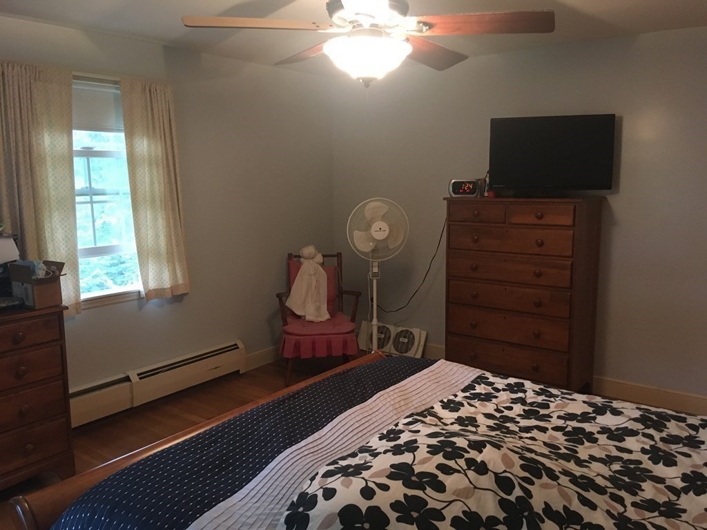 18 Butternut Drive Sutton, MA 01590 - Photo 32 of 34 a bedroom with a bed and flat tv screen on the dresser