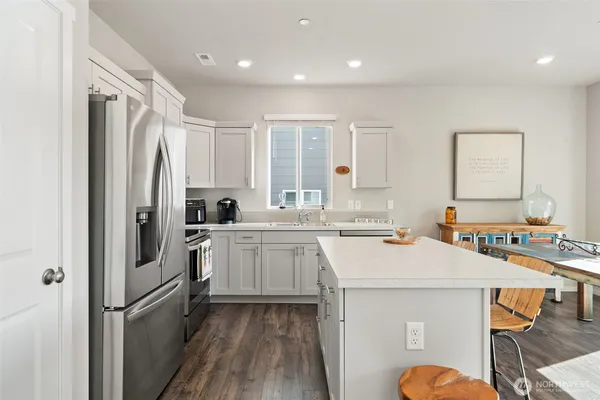 a kitchen with stainless steel appliances granite countertop a refrigerator stove and microwave