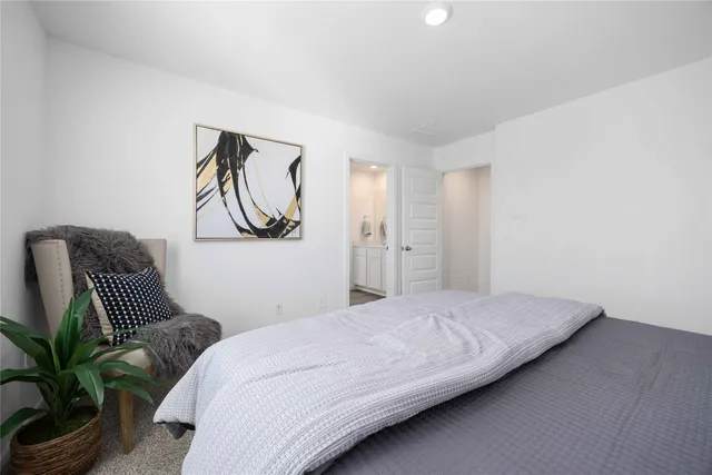 a bedroom with a bed and a potted plant