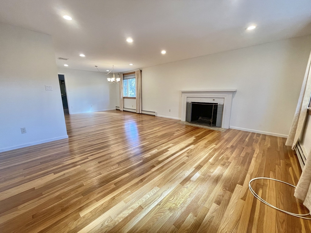 77 Louise Road, Unit 77 Newton, MA 02467 - Photo 3 of 22 a view of an empty room with wooden floor and a window