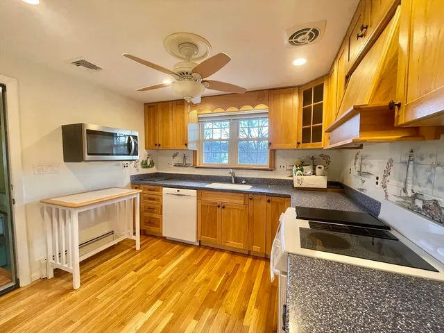 a kitchen with granite countertop a stove a sink and a microwave