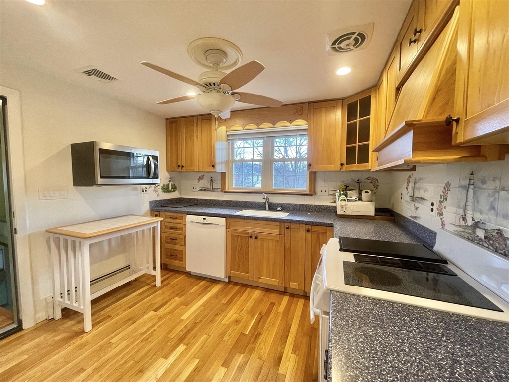 77 Louise Road, Unit 77 Newton, MA 02467 - Photo 6 of 22 a kitchen with granite countertop a stove a sink and a microwave