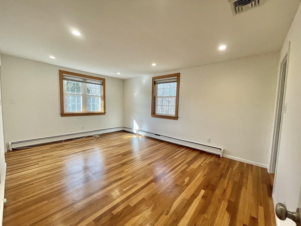 77 Louise Road, Unit 77 Newton, MA 02467 - Photo 8 of 22 a view of an empty room with wooden floor and a window