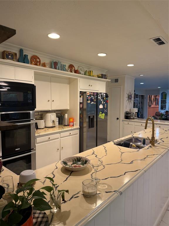 1650 Azteca Drive Fort Worth, TX 76112 - Photo 18 of 37 a kitchen with stainless steel appliances kitchen island granite countertop a sink and cabinets