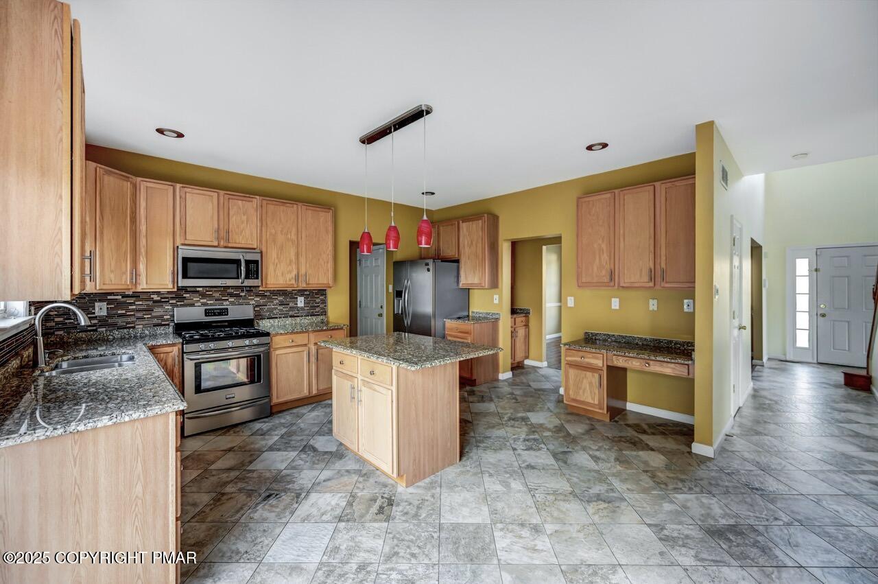 115 Daffodil Drive East Stroudsburg, PA 18301 - Photo 11 of 59 a kitchen with granite countertop a stove top oven a sink dishwasher and a refrigerator