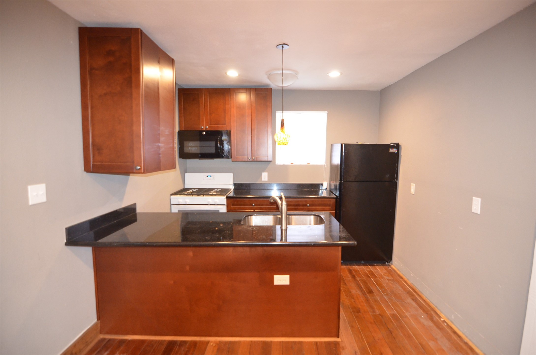 2123 Marion Street, Unit 1 Houston, TX 77009 - Photo 2 of 19 a kitchen with granite countertop a refrigerator a stove a sink a counter space and cabinets